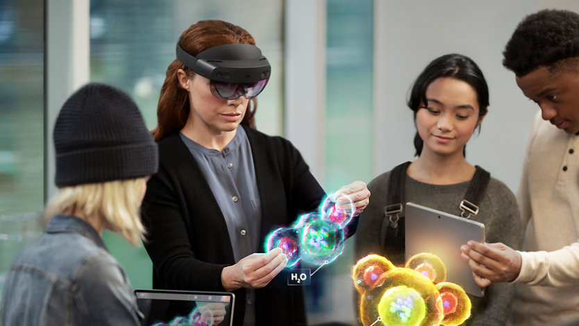 A chemistry teacher uses a Hololens 2 and augmented reality to demonstrate molecular bonds to her class.