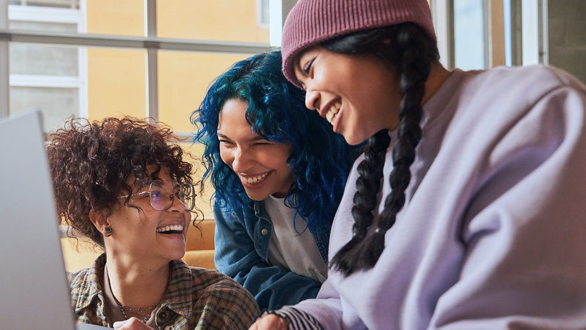 Three friends watching videos on a laptop