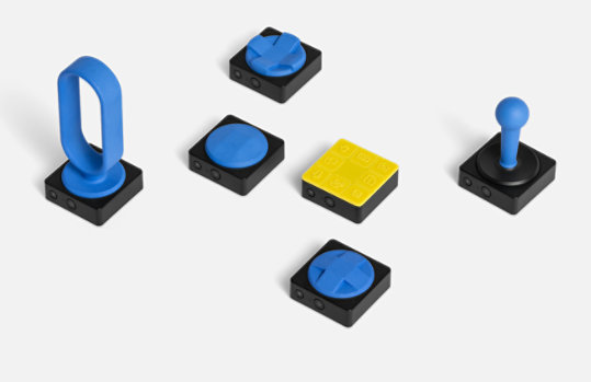 Microsoft Adaptive Buttons with an assortment of 3D printed button toppers.