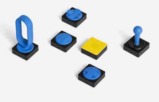 Boutons adaptatifs Microsoft avec un assortiment de designs imprimés en 3D à placer dessus.