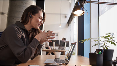 A woman sitting at a table and taking a video call