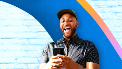 Une personne qui sourit en tenant son téléphone.