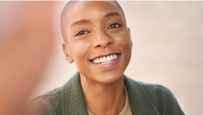 امرأة ثلاثينية العمر ذات بشرة سوداء تبتسم.