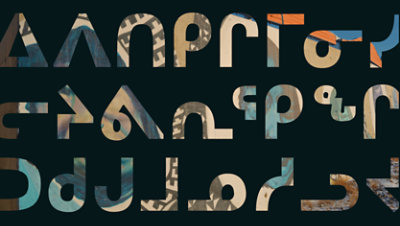 Dark background with large Inuktitut syllabic writing.