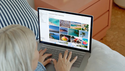 A student looks at vacation pictures in OneDrive on her Surface Laptop.