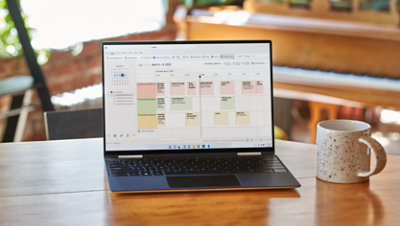 A laptop displays a very full Outlook calendar.