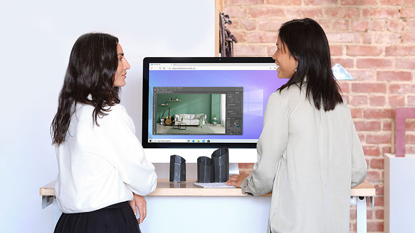 Twee mensen kijken naar een computer waarop Photoshop draait via Windows 365.