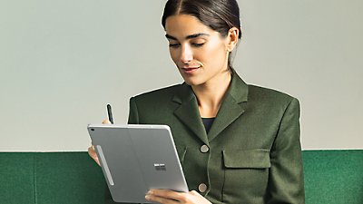 A woman walking while using Microsoft Teams on a Surface Pro 12 inch Platinum device.