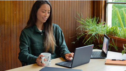 A woman sets up student laptops.