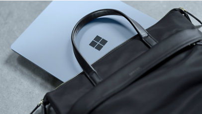 A Surface device partially hidden inside a leather laptop bag. 