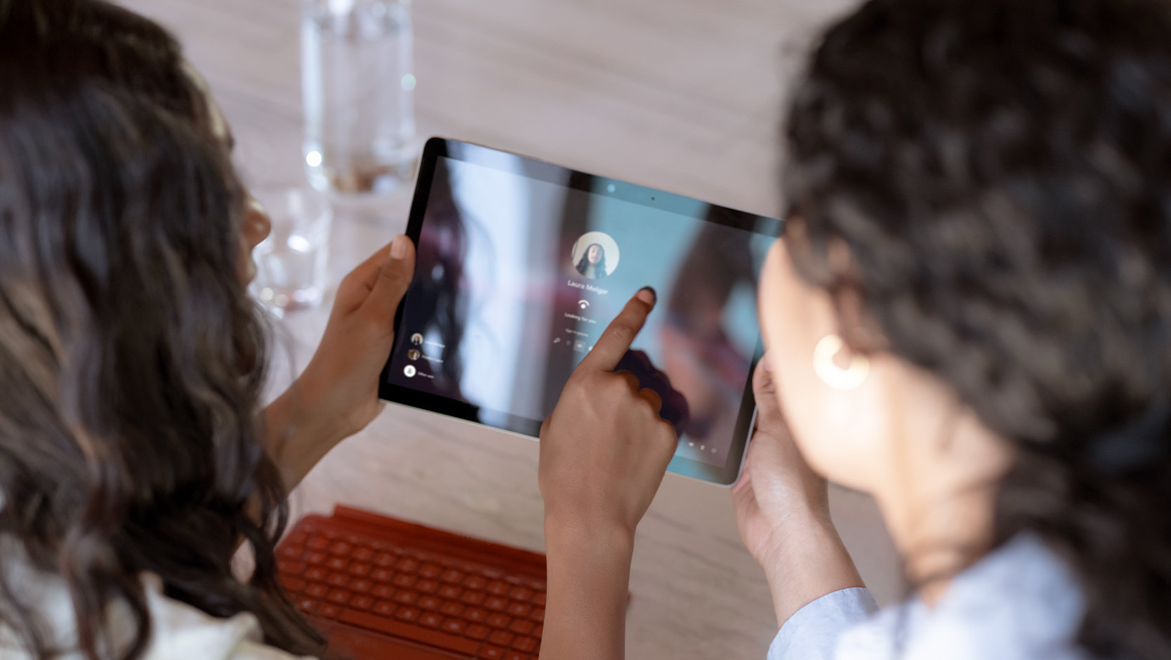 A parent and child stand at a kitchen counter using a Surface Go 3 tablet.