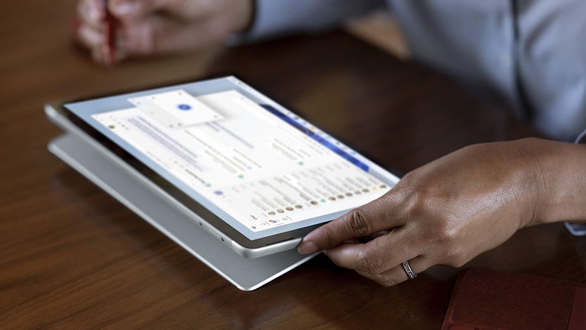 Uma pessoa a utilizar um Surface Go 4 para Empresas, equipado com a experiência completa do Windows 11 Pro.