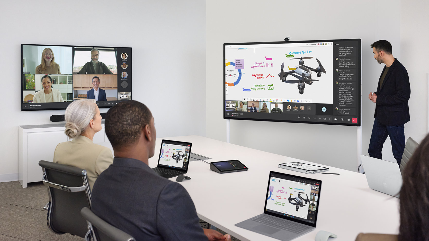 People on Teams and in an office conference room watch a presentation with a Surface Hub 2S 85 inch on the Mobile Stand next to the device on a Wall Mount. 