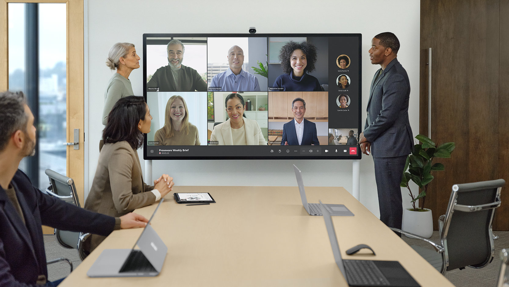 Les membres d’une équipe au bureau et à distance utilisent un Surface Hub 2S pour les entreprises pour se retrouver sur Microsoft Teams. 