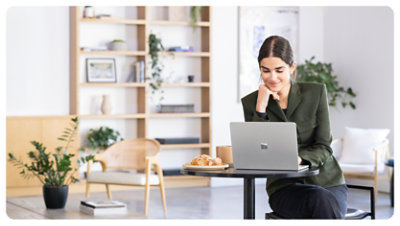 A person smiles while using a Surface Laptop for Business, suggesting the comfort of the display that’s flicker-free and reduces blue light exposure.