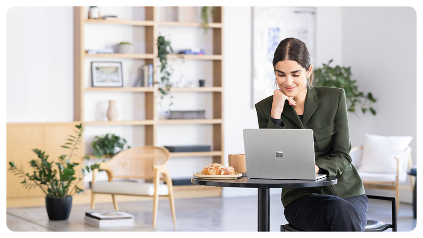 A person smiles while using a Surface Laptop for Business, suggesting the comfort of the display that’s flicker-free and reduces blue light exposure.
