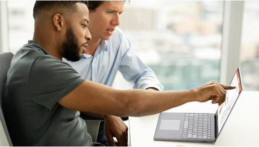 两名同事一起在 Surface Laptop 5 商用版上查看信息。