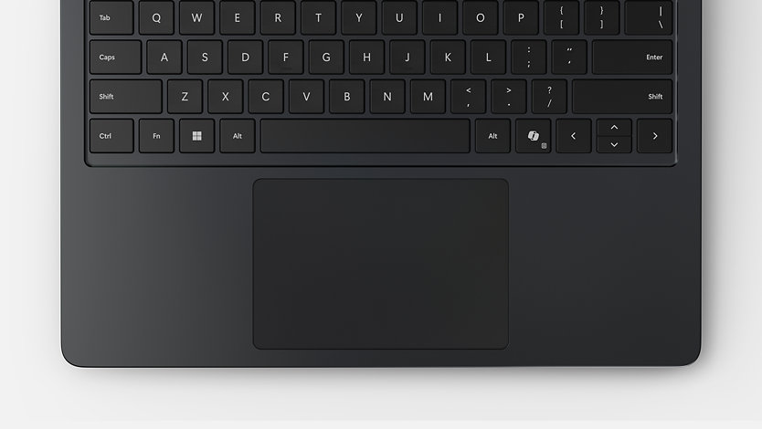 Vista aérea de un teclado y panel táctil de un dispositivo Surface Laptop para empresas. 