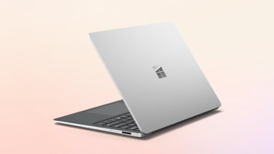 Silver Surface Laptop shown obliquely from behind, partially closed.