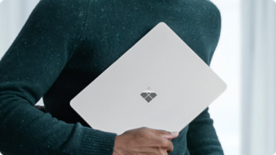 A close-up of a person holding a Surface Laptop for Business, indicating the portability of the device.