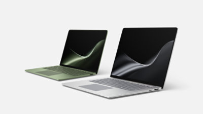A 13.8-inch Surface Laptop in the color Jade beside a 15-inch Surface Laptop in the color Platinum.