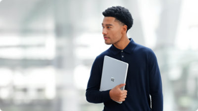 A person holds a Surface Laptop for Business, suggesting the portability of the device.