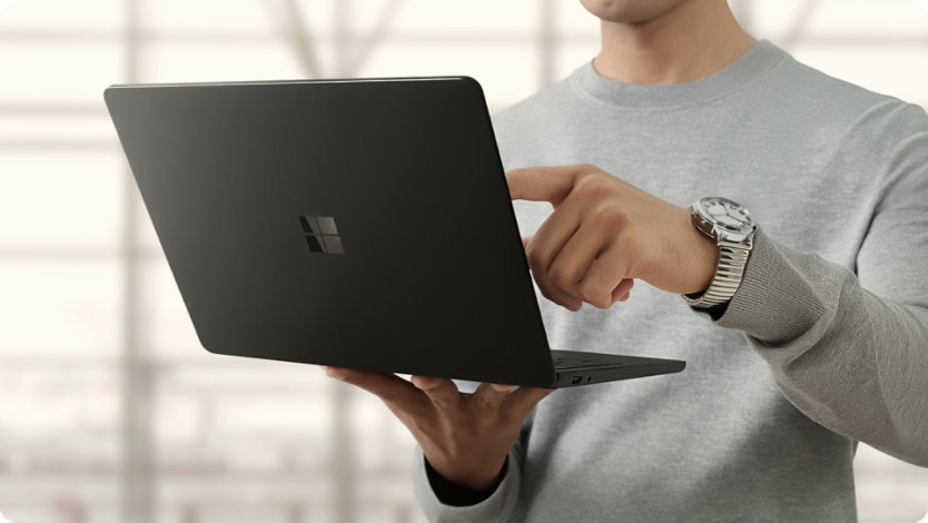 Uma pessoa segura um Surface Laptop para Empresas sem estar ligado à corrente, demonstrando a longa autonomia da bateria.