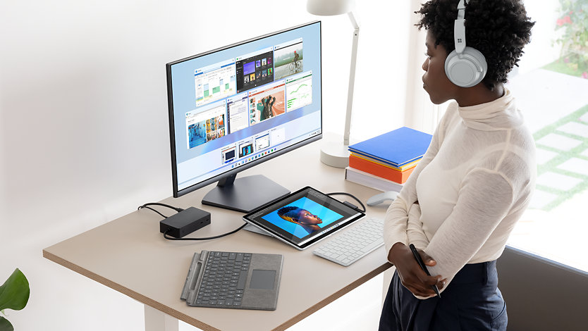 A person using a Pro 9 and various accessories at a desk.