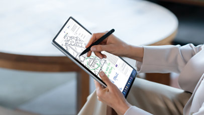 A person uses a Slim Pen to write on the touchscreen of a Surface Pro 10 for Business in the color Platinum.