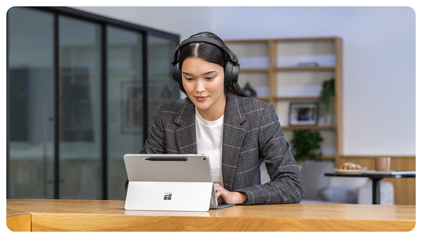 A person uses a Surface Pro for Business with the kickstand engaged.