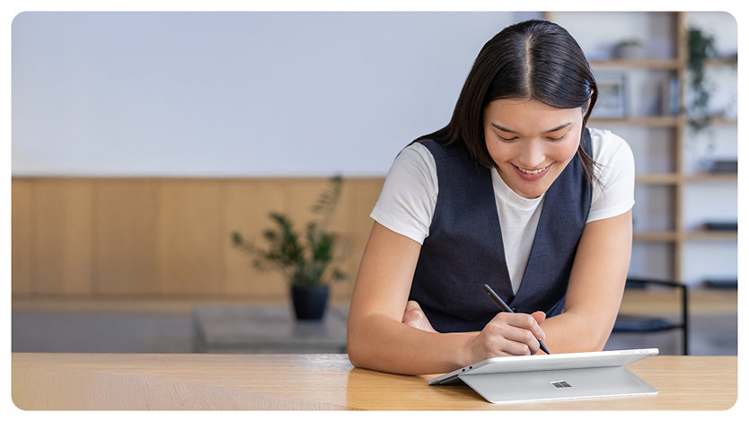 A person uses a Slim Pen to draw on the touchscreen of a Surface Pro for Business.