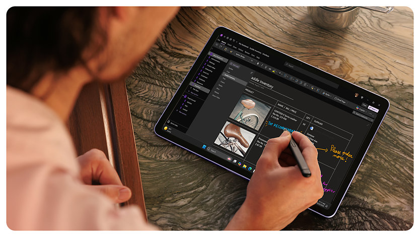 A person uses Surface Slim Pen to make handwritten notes on a Surface Pro. 