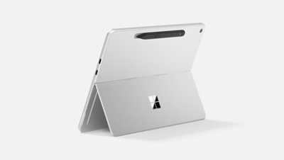 The rear of a 12-inch Surface Pro standing upright using the kickstand, while a Surface Slim Pen magnetically charges on it. 