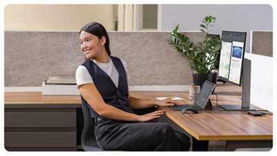 Una persona in ufficio sorride mentre usa un Surface Pro per le aziende.