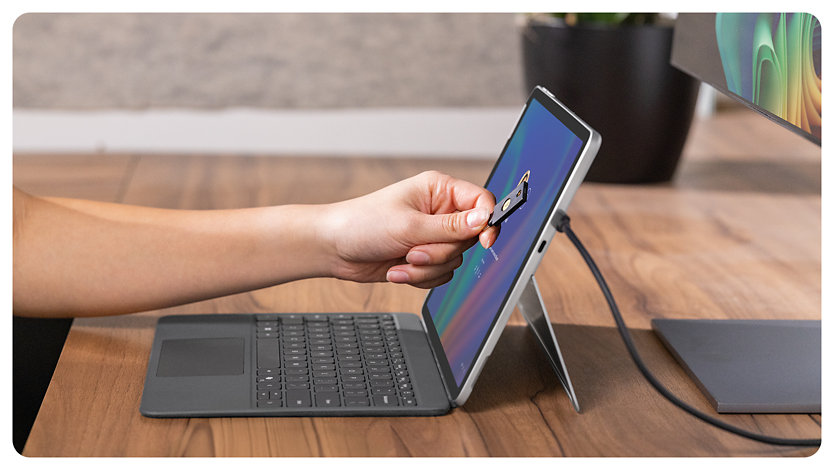 A person uses the integrated NFC reader on a Surface Pro for Business to log in to their device.