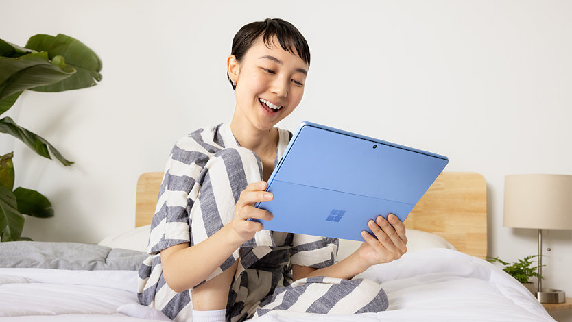 Eine junge Frau mit einem Surface Pro 9. 