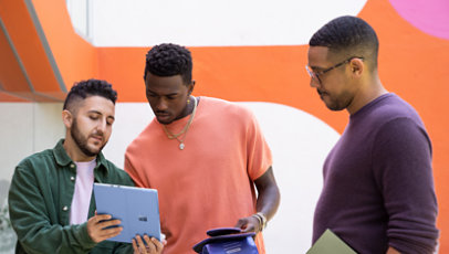 A cluster of friends watch something on a sapphire blue Surface Pro 9.