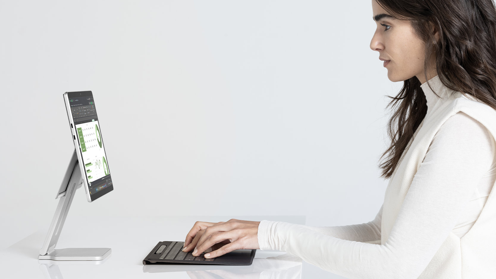 A person types on a detached Surface Pro Flex Keyboard for Business.