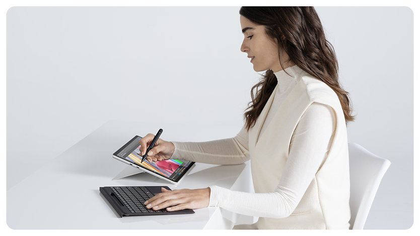 Uma pessoa a utilizar uma Slim Pen para desenhar um design colorido num Surface Pro para Empresas.