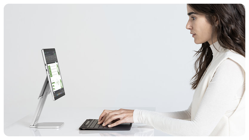 Uma pessoa num Surface Pro para Empresas através de um Teclado Flex para Surface Pro destacado do dispositivo.