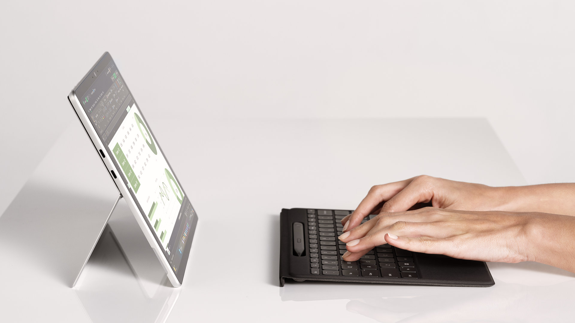 Vue latérale d’une personne tapant sur un clavier Flex pour Surface Pro 13 pouces avec stylet Slim Pen détaché.