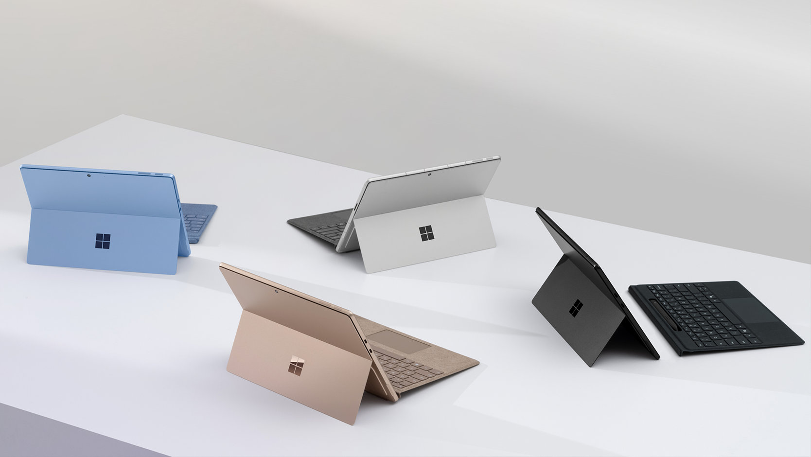 Fyra Surface Pro-tangentbord med pennförvaring-enheter i färgerna Svart, Platina, Safir och Sand.