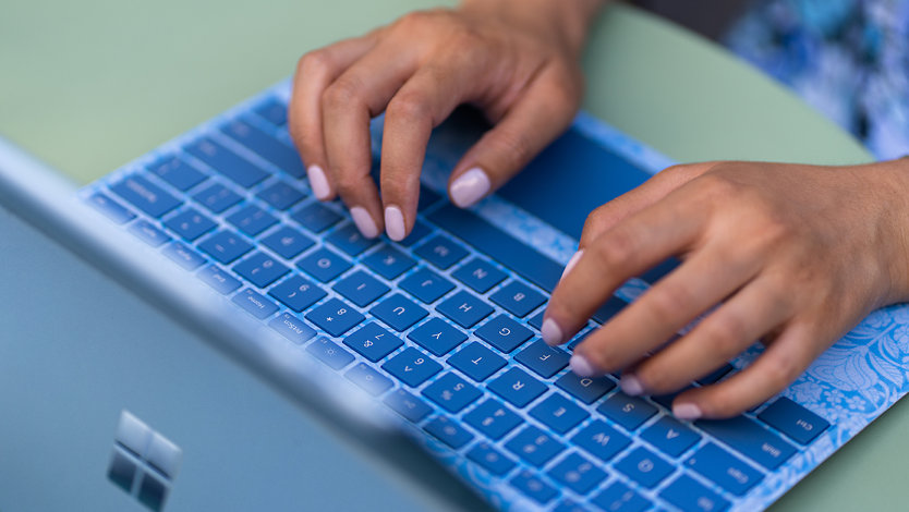 A person types on a Surface Pro Liberty Keyboard.