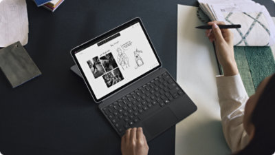 Uma pessoa a utilizar um Surface Pro para Empresas com uma Slim Pen e um Teclado para Surface Pro de 12 polegadas para Empresas.