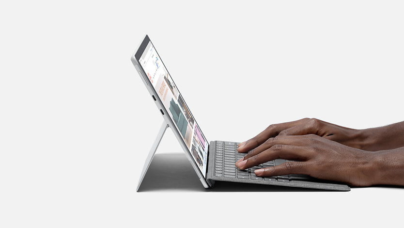 A side view of a person using Surface Pro X.