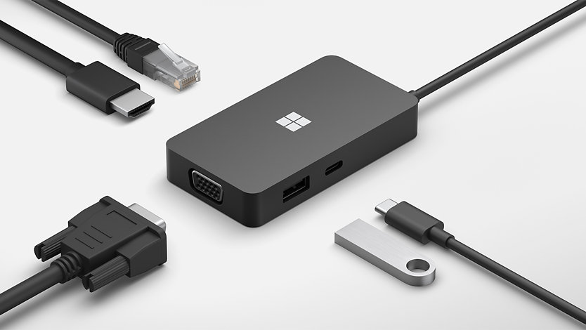 A Surface USB-C Travel Hub surrounded by various connective cables.