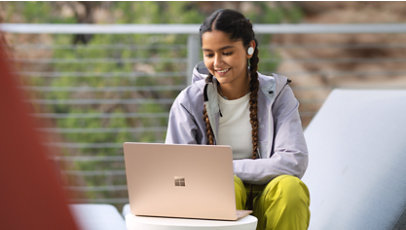 Osoba używająca Surface Laptop 5 na zewnątrz