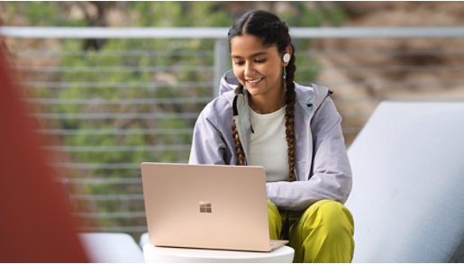 A person using a Surface Laptop 5 outdoors