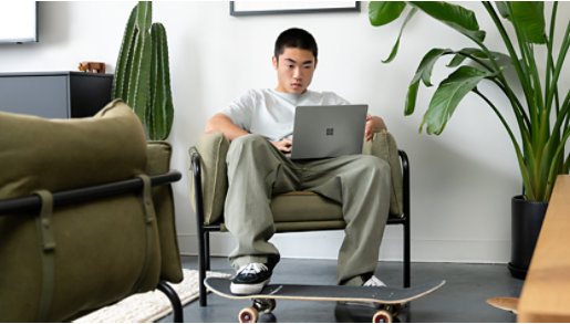 A person using a Sage Green Surface Laptop Go 2