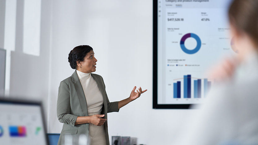 A manager presents data from Power BI to her team. 